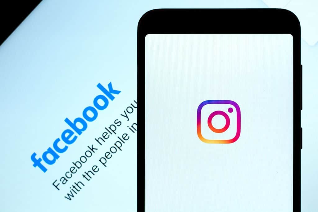 Resumen quincenal 4/1: últimas actualizaciones en tendencias de marketing digital 2 Teléfono móvil que muestra Instagram con el logo de Facebook en el fondo